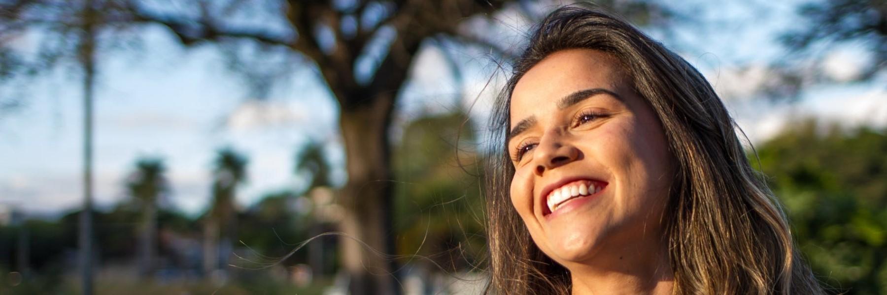 Woman looking up at the sun smiling | Cosmetic Dentist West Greeley CO