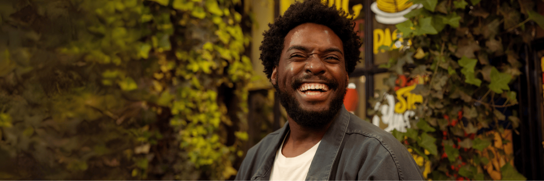 A laughing man sitting on an outdoor patio